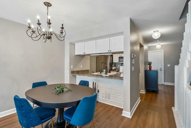 dining space with dark wood-style floors, visible vents, and baseboards