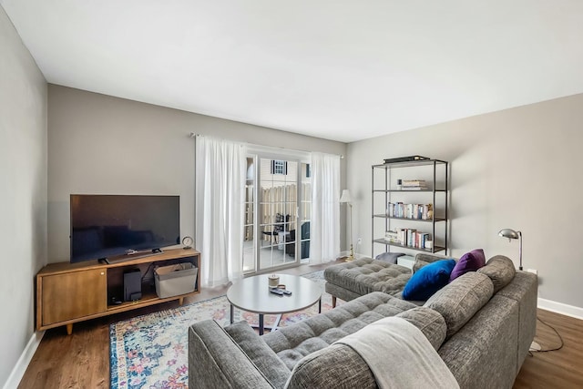 living area with baseboards and wood finished floors