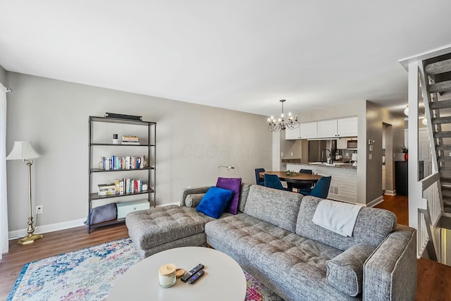 living room featuring dark wood finished floors, baseboards, and an inviting chandelier