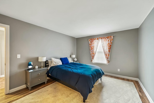 bedroom with baseboards and wood finished floors