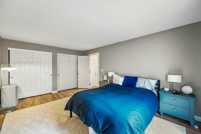 bedroom featuring multiple closets and wood finished floors