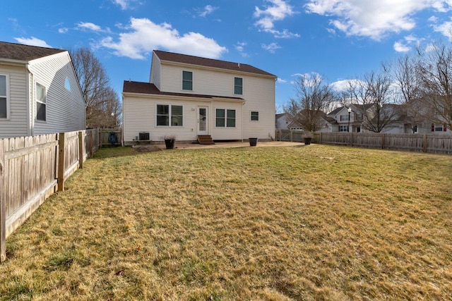 rear view of house featuring entry steps, a fenced backyard, and a yard