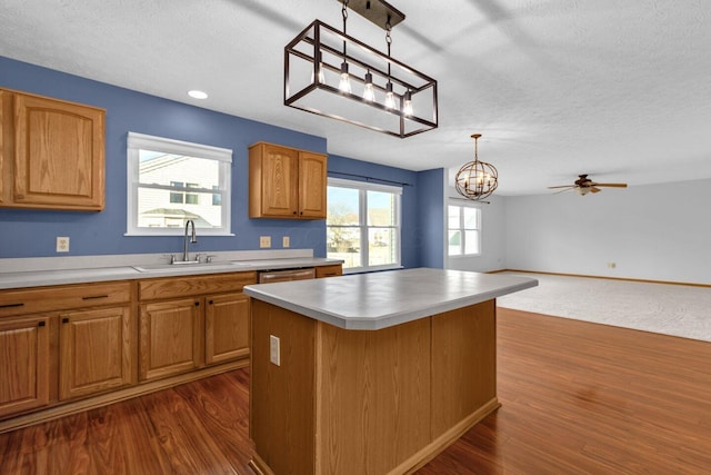 kitchen with a wealth of natural light, pendant lighting, a center island, and a sink