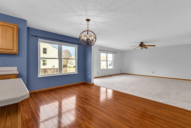 interior space featuring a textured ceiling, wood finished floors, and baseboards