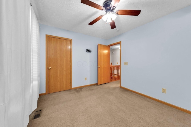 unfurnished bedroom with light carpet, baseboards, visible vents, and a textured ceiling