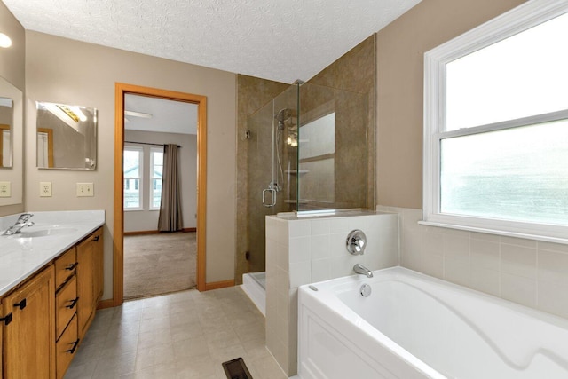 full bathroom featuring a textured ceiling, a garden tub, visible vents, vanity, and a stall shower