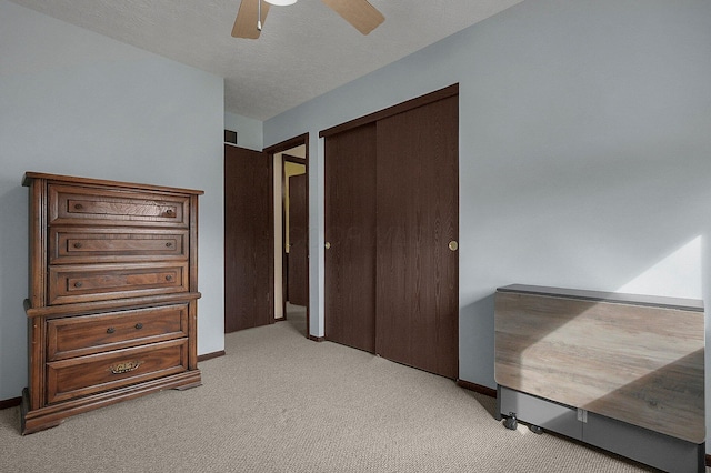 bedroom with carpet, a closet, ceiling fan, a textured ceiling, and baseboards