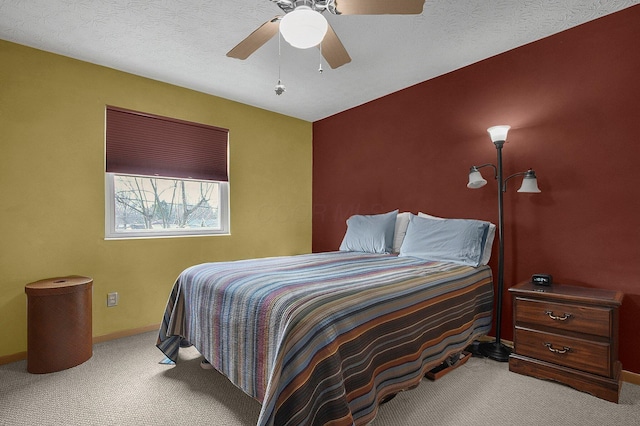 carpeted bedroom featuring ceiling fan, baseboards, and a textured ceiling