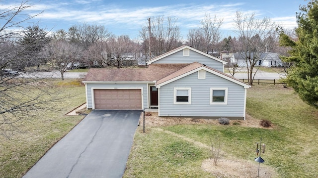 view of front of property with driveway, a front lawn, roof with shingles, and an attached garage