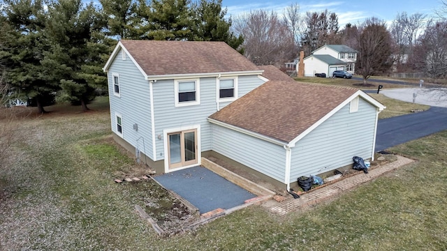 exterior space with a yard and a shingled roof