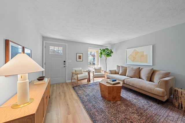 living room featuring light wood-style floors and a textured ceiling