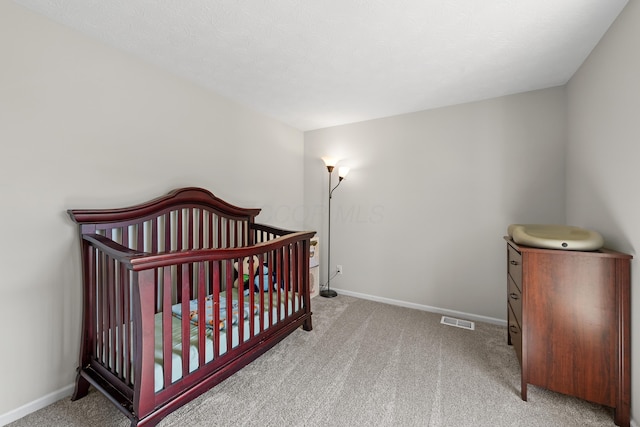 carpeted bedroom featuring visible vents and baseboards