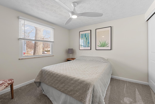 carpeted bedroom with a ceiling fan, baseboards, and a textured ceiling