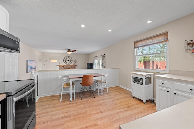 kitchen featuring appliances with stainless steel finishes, light countertops, light wood-type flooring, white cabinetry, and recessed lighting