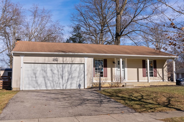 ranch-style house with covered porch, aphalt driveway, and a garage