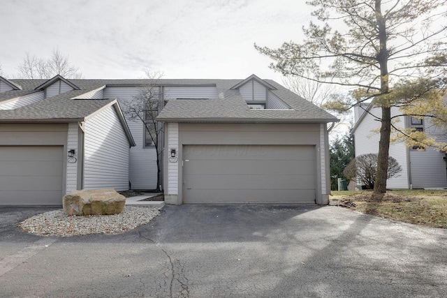 view of front of property with a garage and roof with shingles