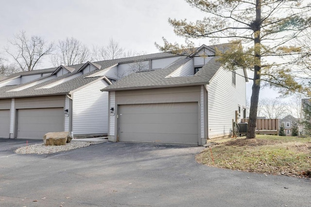 view of front of home with aphalt driveway and roof with shingles