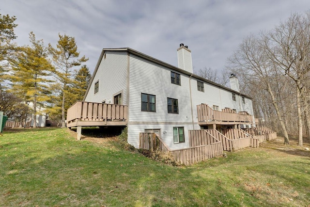 back of house with a wooden deck, a chimney, and a yard