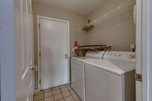 laundry area with laundry area, washing machine and dryer, and light tile patterned floors