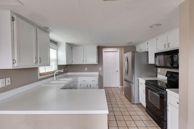 kitchen with black appliances, white cabinets, a sink, and light countertops