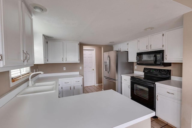 kitchen featuring light tile patterned floors, light countertops, black appliances, white cabinetry, and a sink