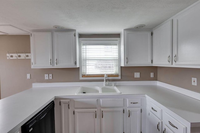 kitchen featuring a sink, white cabinetry, light countertops, and dishwasher