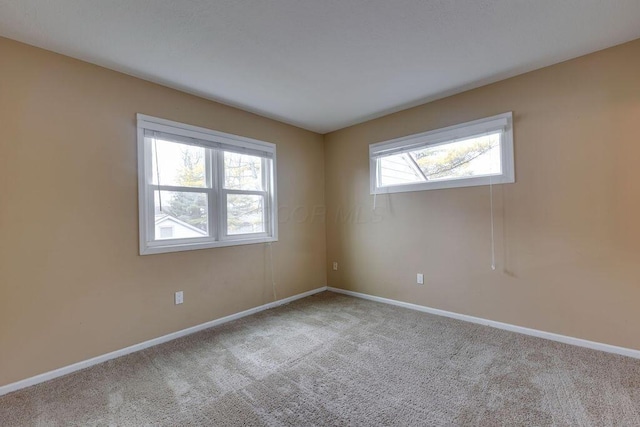 empty room featuring carpet floors and baseboards