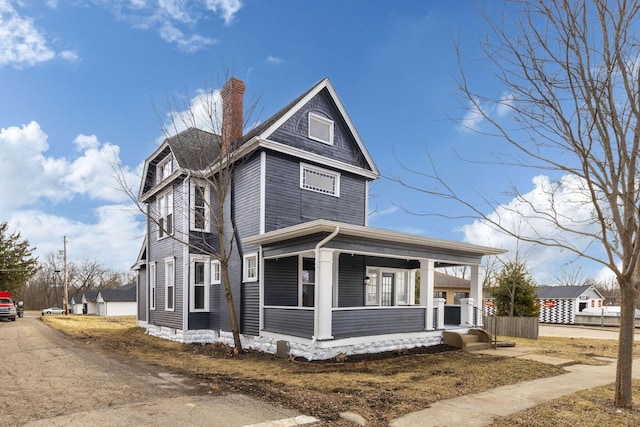 view of front of home with a chimney and a porch