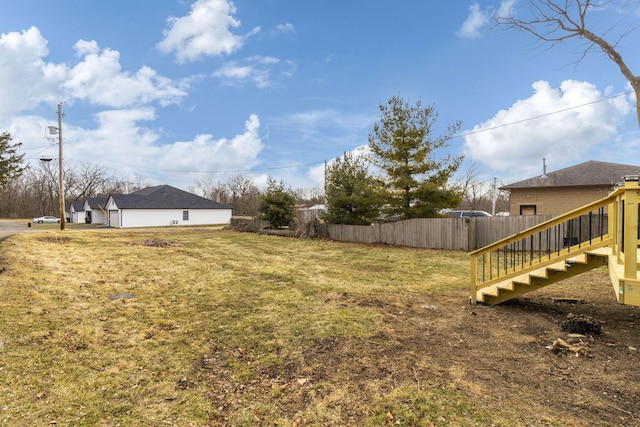 view of yard featuring fence and stairs