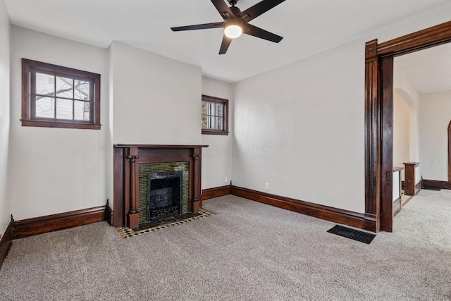 unfurnished living room featuring a fireplace with flush hearth, carpet flooring, and visible vents