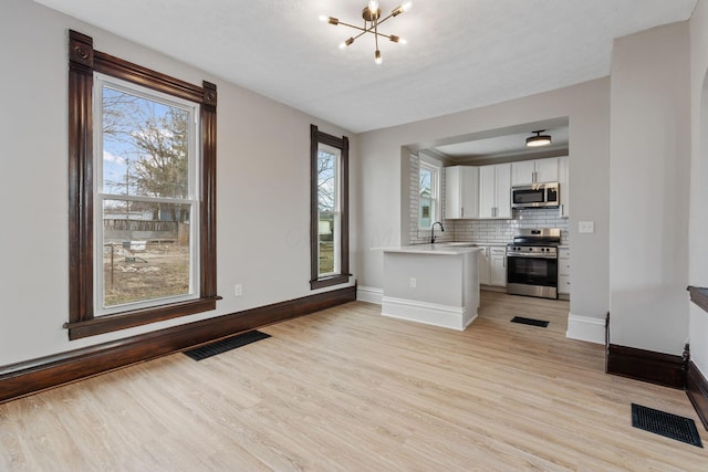 kitchen featuring visible vents, appliances with stainless steel finishes, white cabinets, and light countertops