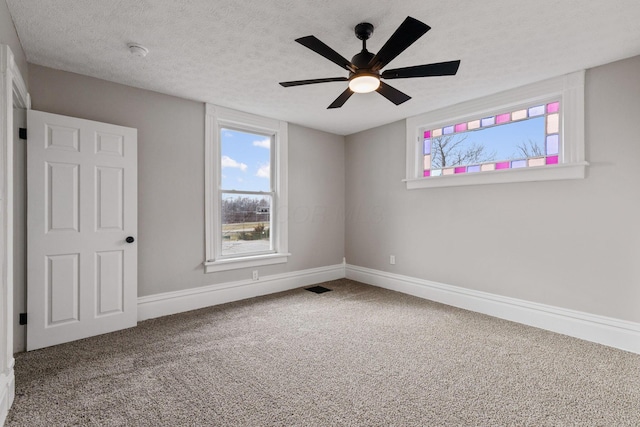 unfurnished bedroom featuring carpet floors, visible vents, baseboards, and a textured ceiling