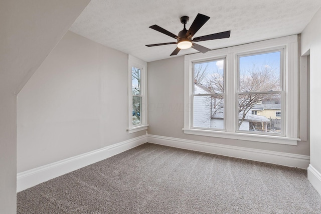 bonus room with carpet floors, a ceiling fan, baseboards, and a textured ceiling