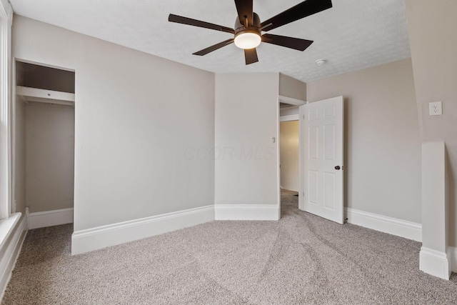 unfurnished bedroom featuring carpet, a textured ceiling, and baseboards