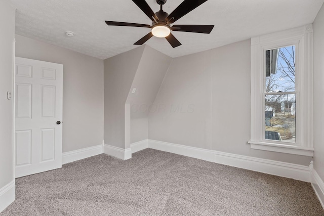 bonus room with a textured ceiling, carpet floors, a ceiling fan, and baseboards