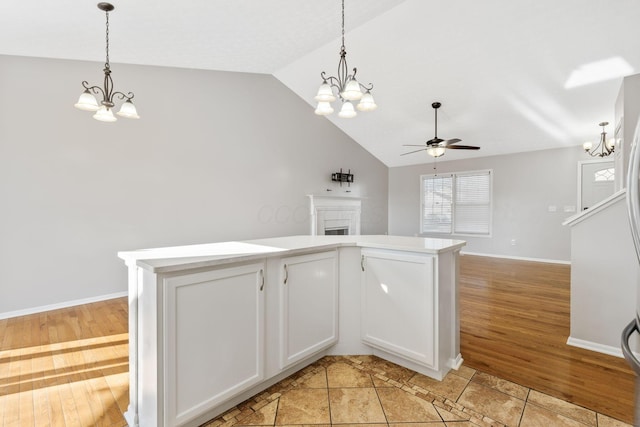 kitchen featuring light wood-type flooring, lofted ceiling, open floor plan, and hanging light fixtures