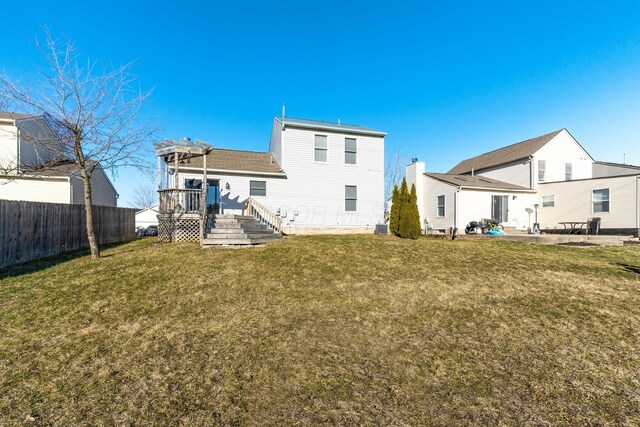 back of property with a deck, a patio, central AC, fence, and a yard