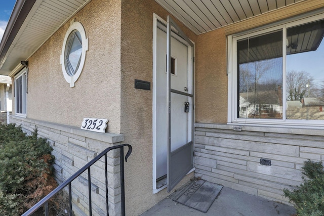 entrance to property featuring stucco siding