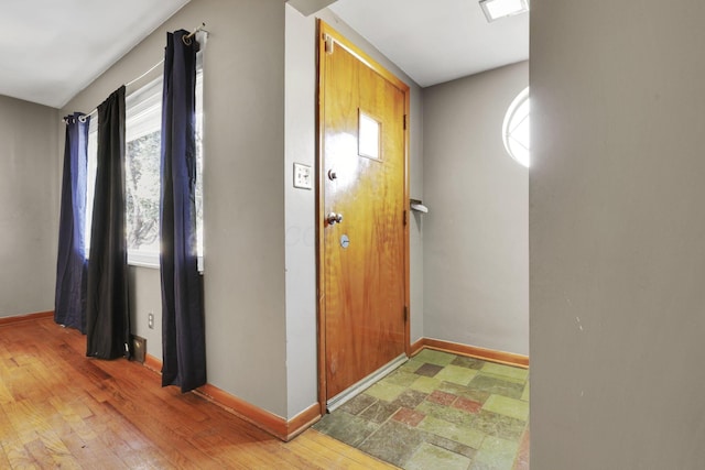 foyer entrance with light wood-type flooring and baseboards