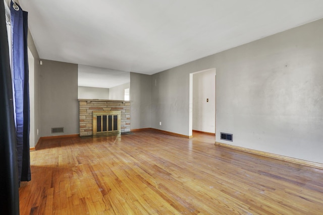 unfurnished living room with visible vents, light wood-type flooring, and baseboards