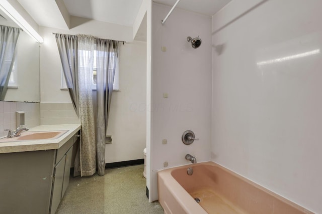 full bathroom featuring toilet, backsplash, washtub / shower combination, baseboards, and vanity