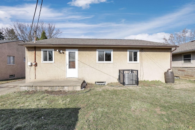 rear view of property with stucco siding and a lawn