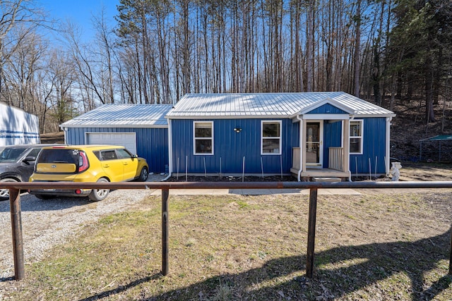 view of front of home featuring an outdoor structure, fence, and metal roof