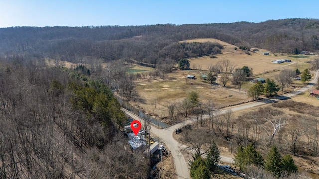 birds eye view of property featuring a view of trees and a rural view