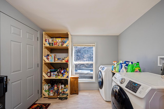 clothes washing area with laundry area, separate washer and dryer, and light wood finished floors