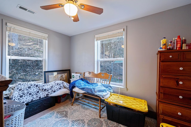 bedroom featuring a ceiling fan, wood finished floors, and visible vents