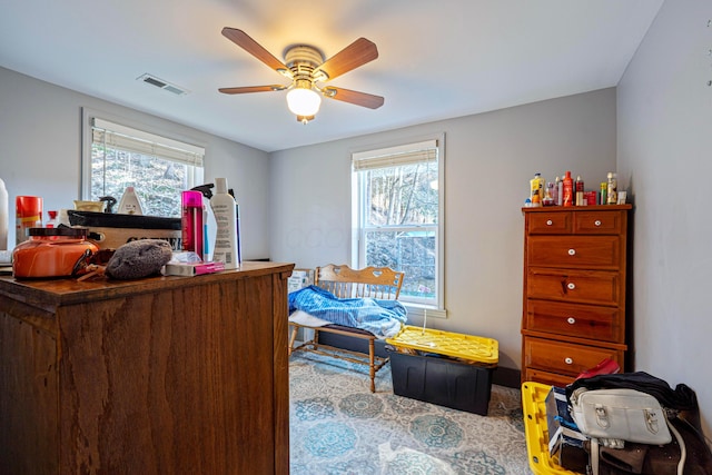 office space featuring a wealth of natural light, visible vents, and ceiling fan