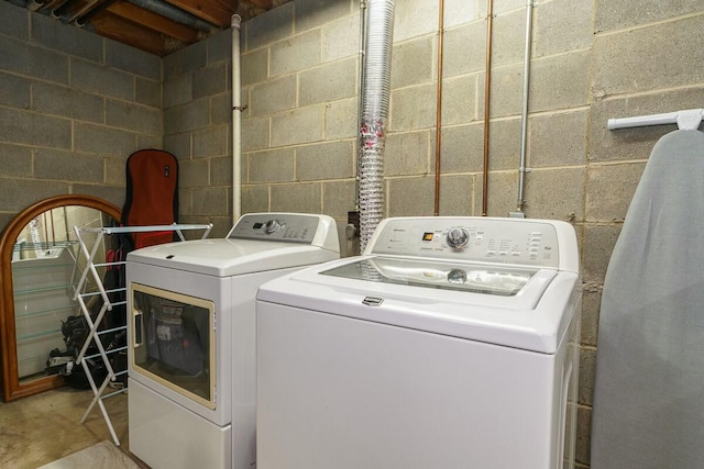 laundry area featuring washing machine and clothes dryer, laundry area, and concrete block wall