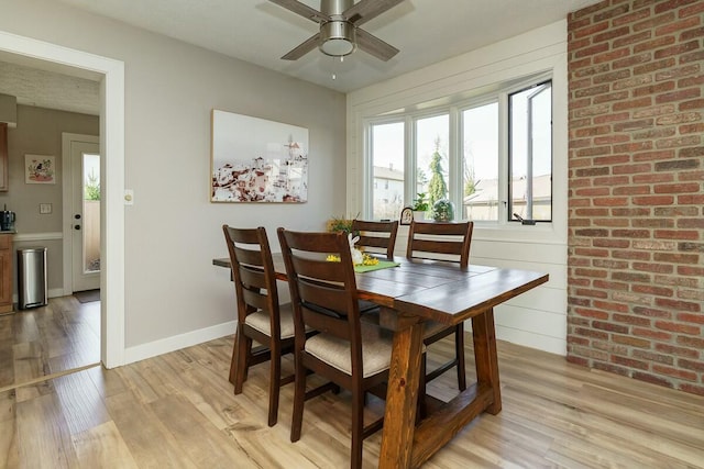 dining space with baseboards, light wood-style floors, and ceiling fan