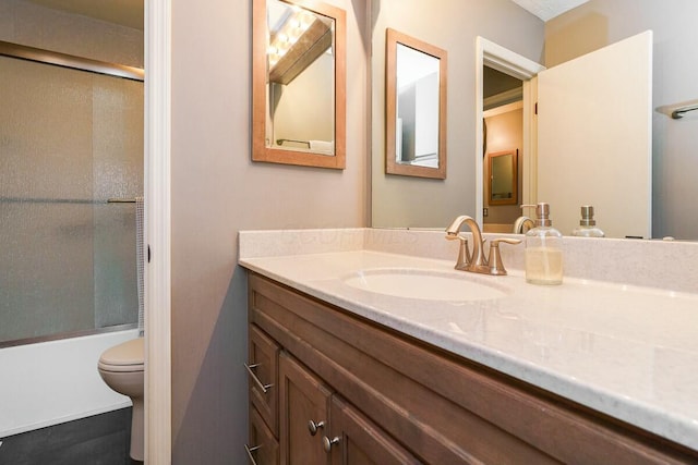 bathroom with enclosed tub / shower combo, toilet, and vanity